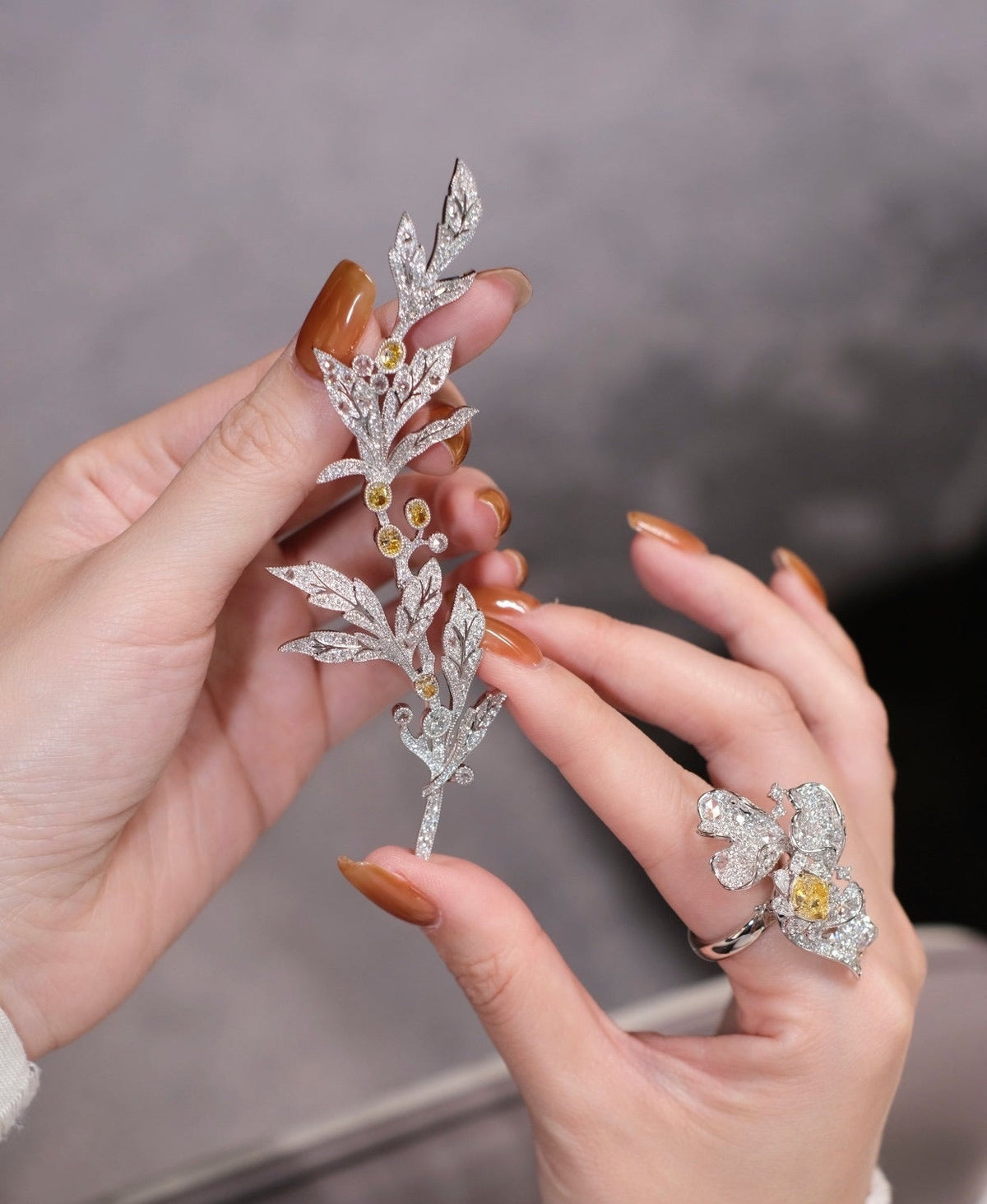 Loose lab grown diamonds in a presentation tray, one held in tweezers